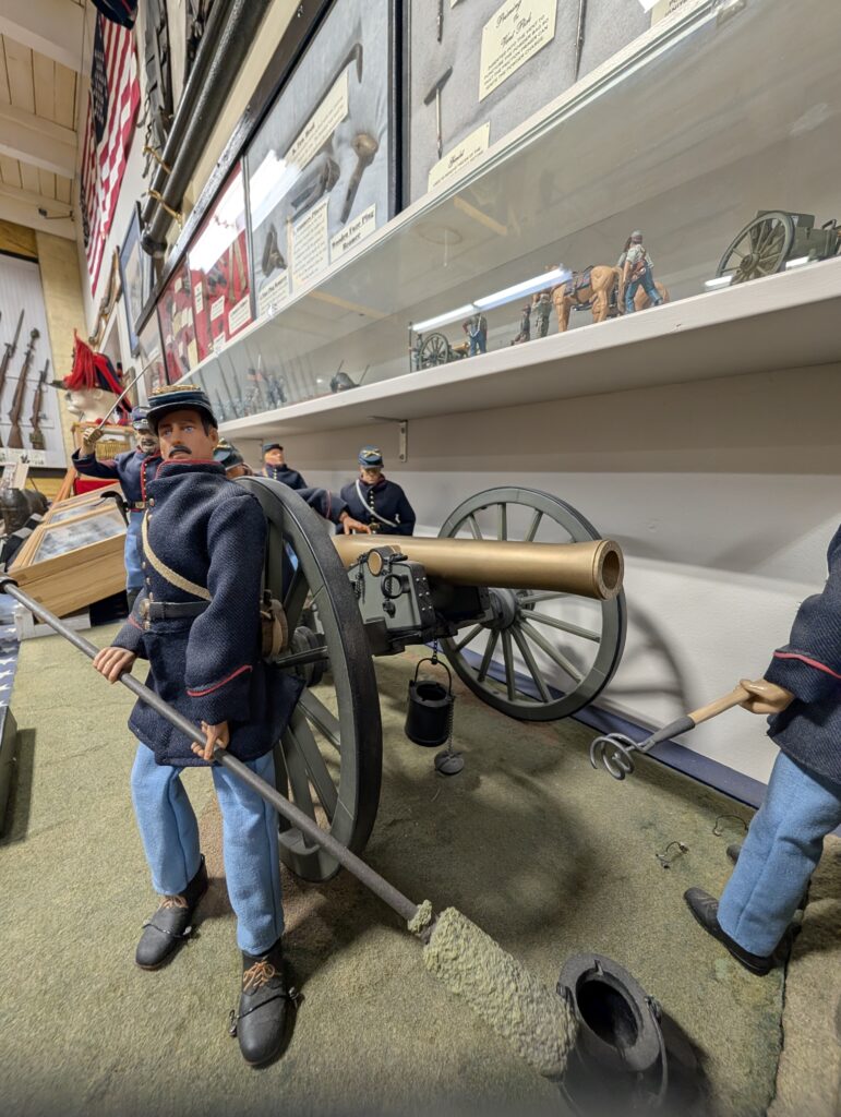 A museum diorama featuring large-scale figures of a Union Army artillery crew from the American Civil War manning a field cannon.