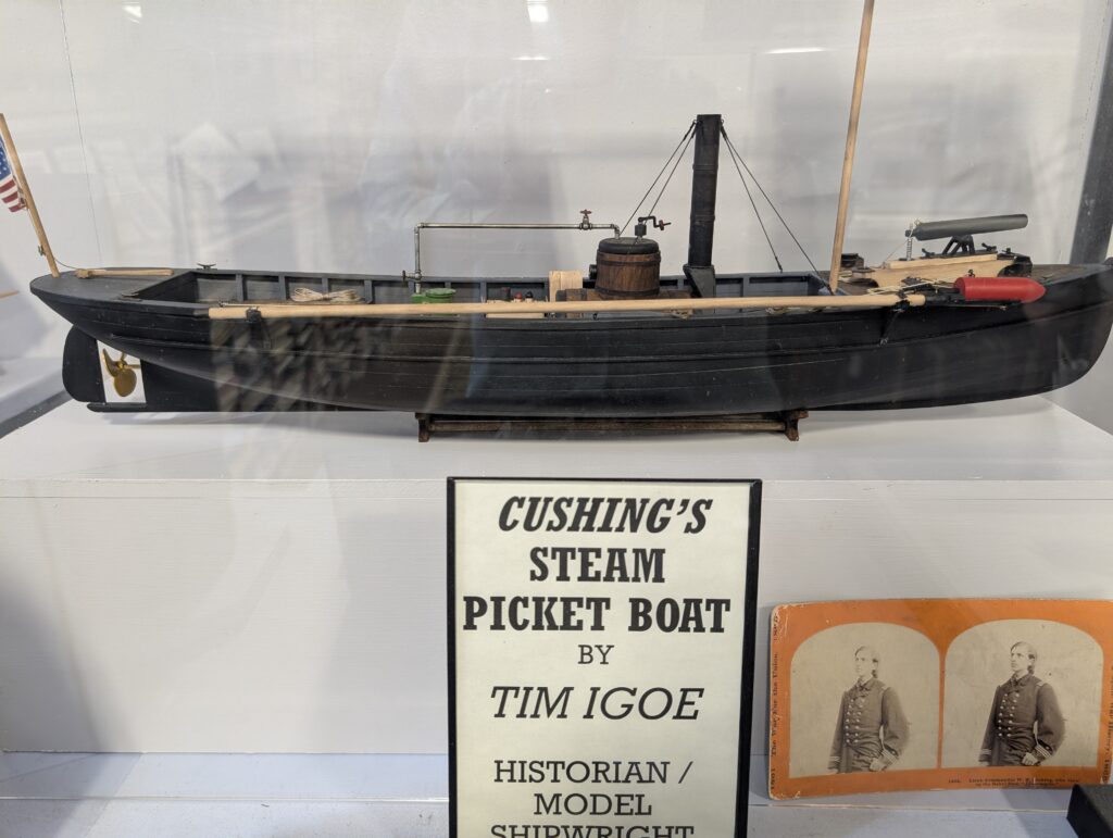 A detailed model of Cushing's Steam Picket Boat, displayed in a museum case.